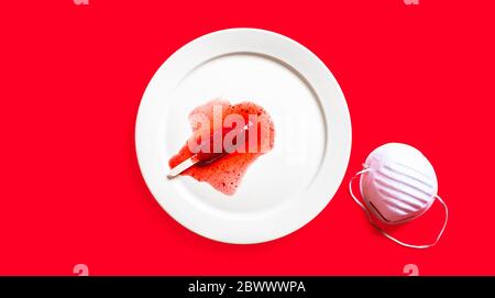 Delicious defrosted strawberry popsicles and medical mask over red background Stock Photo