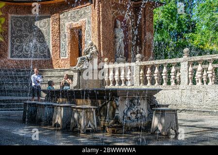 trick fountains hidden in a dinner table and sculptures at the pond in Public Gardens of Hellbrunn Palace (Schloss Hellbrunn) in Salzburg Stock Photo