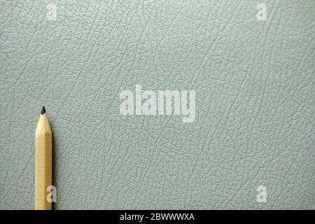 Pencil on Old Gray Leather Texture Background. Stock Photo