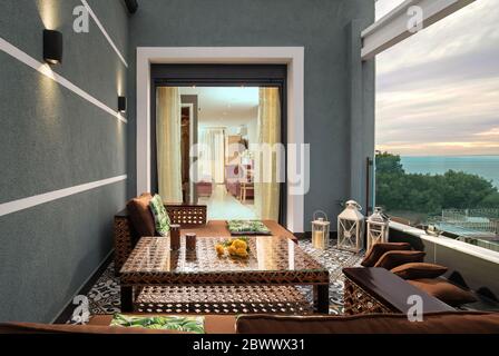 Oriental style interior of open air terrace with wicker furniture in luxury hotel. Traditional arabic decoration of living room in modern apartment Stock Photo