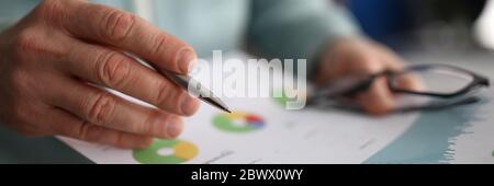 Male hand holding paper with financial statistics Stock Photo