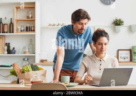 Young couple using laptop computer at home they ordering products online Stock Photo