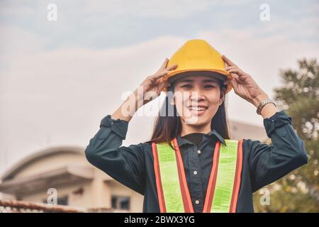 Asian Woman Engineering Yellow helmet hard hat safety Stock Photo