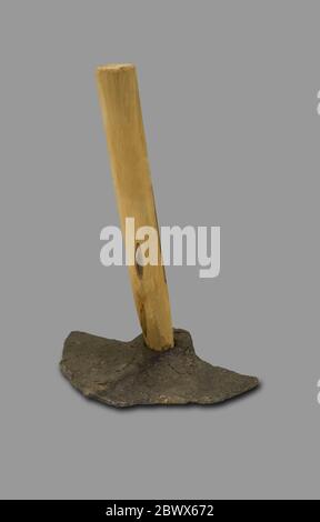 Montilla, Spain - March 2nd, 2019: Roman hoe. Agricultural iron tool with replica wooden handle and original wide head. Isolated. Montilla Local Histo Stock Photo