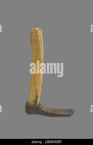 Montilla, Spain - March 2nd, 2019: Roman draw hoe. Agricultural iron tool with replica wooden handle and original head. Isolated. Montilla Local Histo Stock Photo