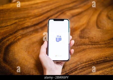BANGKOK, THAILAND - MAY 17, 2020: A user opens the Microsoft Teams application on smartphone screen on the wooden desk. Microsoft Teams is a popular a Stock Photo