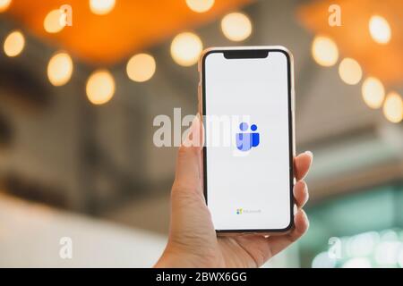 BANGKOK THAILAND - MAY 17, 2020 : Close up image of a user  is holding IphoneX and showing the Microsoft Teams Logo on the device screen. Stock Photo