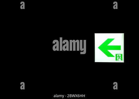 Emergency Exit Sign in the Dark Room. Stock Photo