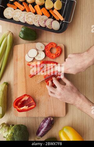 High angle view of man cutting vegetables with knife on cutting board Stock Photo