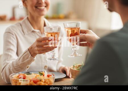 Close-up of young couple having dinner together at the table and toasting with glasses of wine Stock Photo