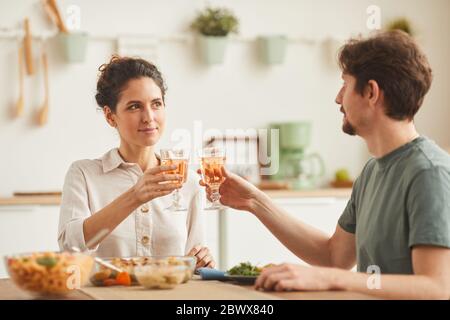 Young couple sitting at the table and celebrating with wine during dinner at home Stock Photo