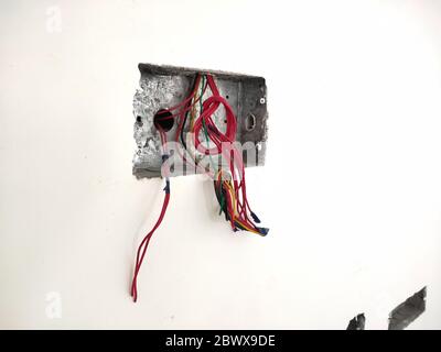 unfinished electrical steel junction box on white brick wall. Household electric installation work, home wiring repair. Upgrade the power system in th Stock Photo