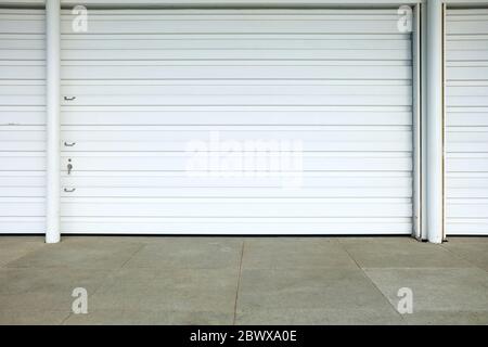 White Folding Metal Door with Concrete Pavement. Stock Photo