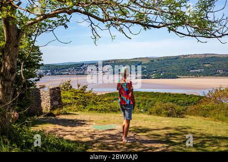 Woman admiring the view from Arnside Knot Cumbria of Grange over Sands across  the Kent estuary at the seaside  resort of Arnside Stock Photo