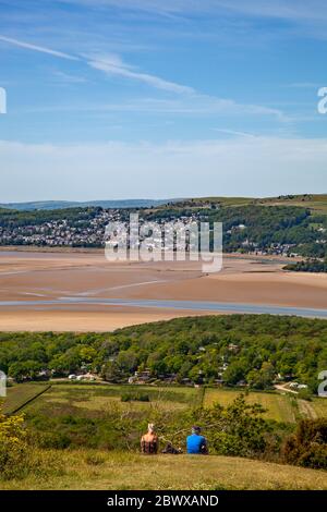 People sitting admiring Ariel view from Arnside Knot Cumbria of Grange over Sands across  the Kent estuary at the seaside  resort of Arnside Stock Photo