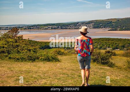 Woman admiring Ariel view from Arnside Knot Cumbria of Grange over Sands across  the Kent estuary at the seaside  resort of Arnside Stock Photo