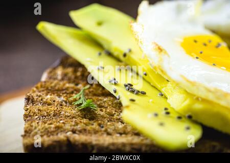 fried egg on toast with avocado, vegetarian food. Stock Photo