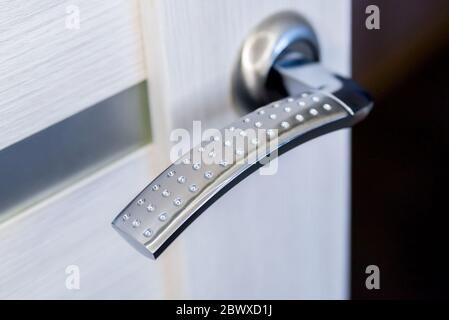 Closeup of metal doorhandle on wooden door Stock Photo
