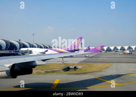 BANGKOK, THAILAND - NOVEMBER 17, 2019: Airplane wing of Thai Airway with Suvarnabhumi airport Thailand background. Thai Airway was founded in March 19