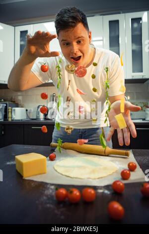 man making pizza ingredients like salami mushrooms olive cheese freeze in air Stock Photo