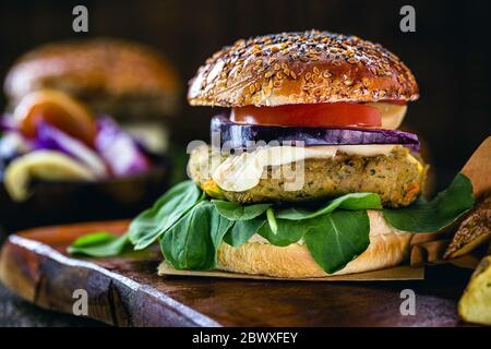 Vegan hamburger, Sandwich made without meat, with glass of green juice in the background. Sandwich with pepper, mushroom, tomato, lettuce and protein