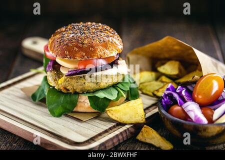 Vegetarian hamburger, sandwich made without meat, with portion of french fries. Sandwich with mushroom, tomato, lettuce, arugula, protein and mushroom