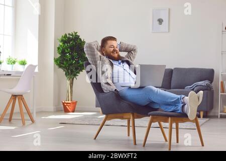 Work online at home office. Funny fat man working laptop online meeting chatting in a home office. Stock Photo