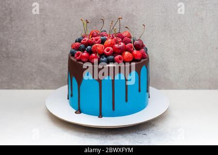 Vanilla cupcakes in gift box with berry sauce, whipped cream and fresh cherries on top. Selective focus. Stock Photo