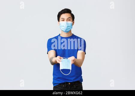 Different emotions, social distancing, self-quarantine on coronavirus and lifestyle concept. Handsome asian male volunteer, guy in personal protective Stock Photo