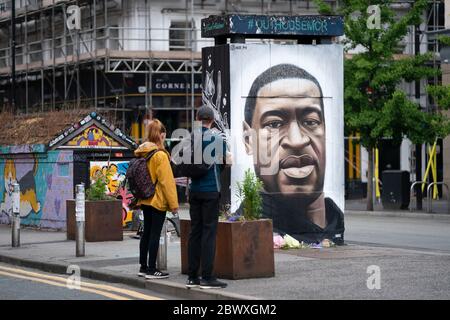 Manchester, UK. 3rd June, 2020. Members of the public are seen by a mural of George Floyd the 46-year-old black man who died in Minneapolis, Minnesota on May 25th after Derek Chauvin, a white officer with the Minneapolis Police Department, pressed his knee to Floyd's neck, Manchester, UK. Credit: Jon Super/Alamy Live News. Stock Photo