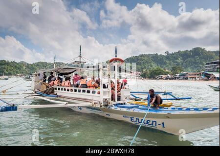 Boat captains and their help set up the long tail boats that take the tourists out to the lagoons, beaches and Islands around El Nido, Palawan. Stock Photo