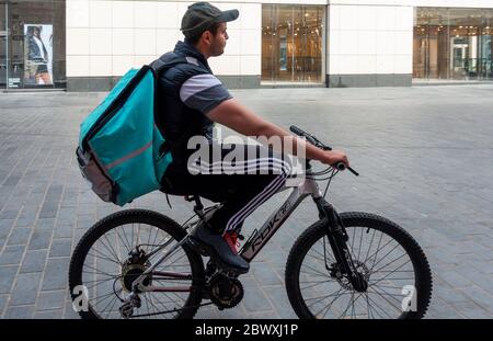 Man on a bicycle doing a deliveroo food delivery in Liverpool Stock Photo