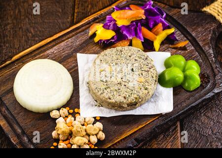 vegan hamburger based on various vegetables and various types of soy or chickpeas, without frying, on a rustic wooden background.Concept of healthy ve Stock Photo