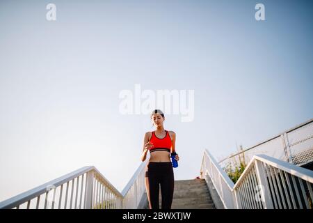 Weight loss - portrait of happy fitness girl. Young smiling woman is  measuring her perfect waist with tape measure and showing diet result.  Studio sho Stock Photo - Alamy