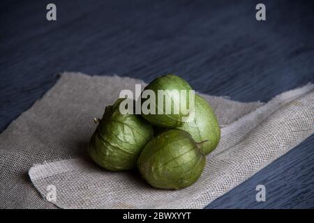 Raw green tomatillos on wood table Stock Photo