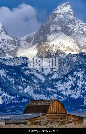 Sunrise at the John Moulton Barn against a backdrop of the dramatic Grand Teton mountain, the highest mountain in the Teton mountain range Stock Photo