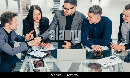 close up. business colleagues shaking hands over an office Desk. Stock Photo