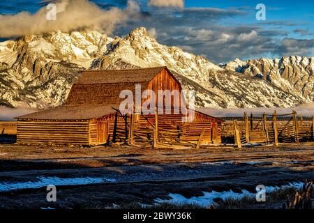 Sunrise at the John Moulton Barn against a backdrop of the dramatic Teton mountain range Stock Photo