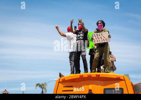 Protesters on top of a bus at a Black Lives Matter protest over the killing of George Floyd: Fairfax District, Los Angeles, CA, USA, May 30, 2020 Stock Photo