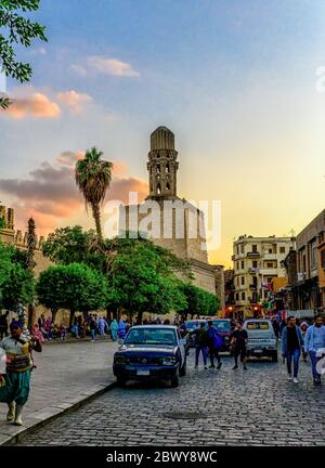 The massive Salient of the El Hakim Mosque Minaret towers above the outer walls of the city at the Southern end of Al-Muizz Street in Islamic Cairo Stock Photo
