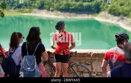 Cyclist Resting in Front of Lake As Three-Month Strict Coronavirus Covid-19 Lockdown Measures Are Lifted and Italians Approach Summer Time in Freedom Stock Photo