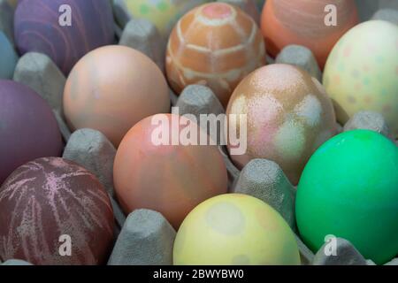 various hand dyed easter eggs in an egg carton Stock Photo