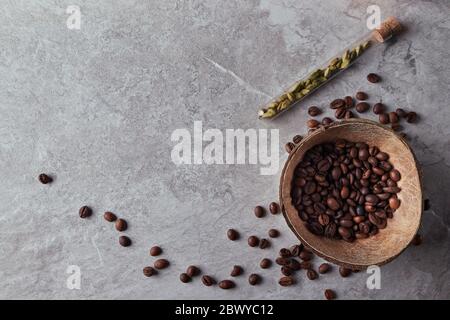 Overhead view of roasted coffee beans in coconut shell on rustic wooden background, Still life photography with roasted coffee beans Stock Photo