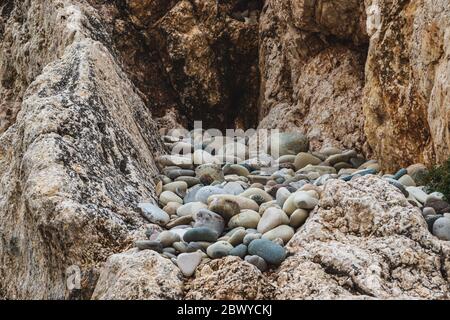 A close up view of smooth polished multicolored stones washed ashore on the beach. Stock Photo