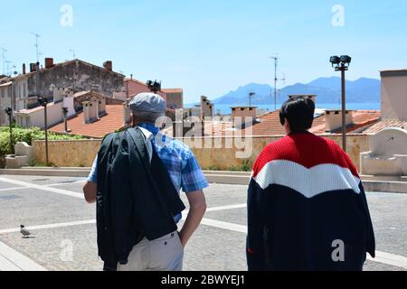 Elderly couple in the city of Cannes in France enjoying the view of the old town. Back to normal life after pandemic. Quarantine is over. Stock Photo