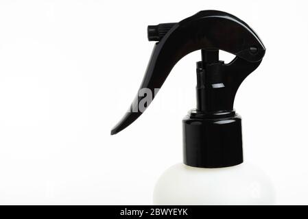A close-up of the top portion of a black and white liquid spray plastic dispenser bottle set on a plain white background. Stock Photo