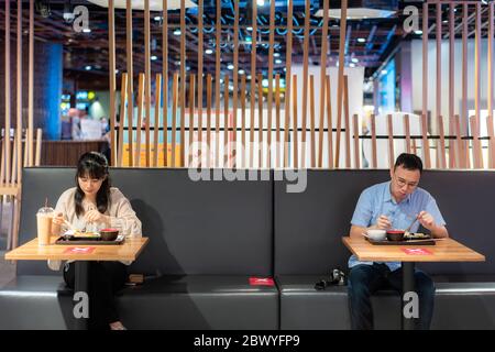 Asian man and woman eating food on table by one person one table in food court for social Distancing 6 feets concept protection of Coronavirus Covid-1 Stock Photo