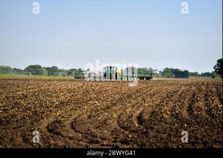 Maple Park, Illinois, USA. Farmer in his tractor applying chemicals to recently planted fields in northeastern Illinois. Stock Photo