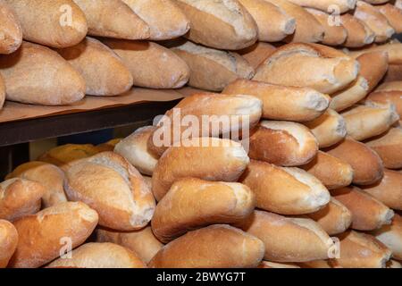 different fresh bread on the shelves in bakery.  Rows of fresh bread loafs lying on the shelf. Bakery shop concept Stock Photo