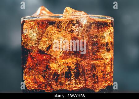 Cola soda drink in glass with ice cubes and bubbles, macro photo, vintage toned Stock Photo